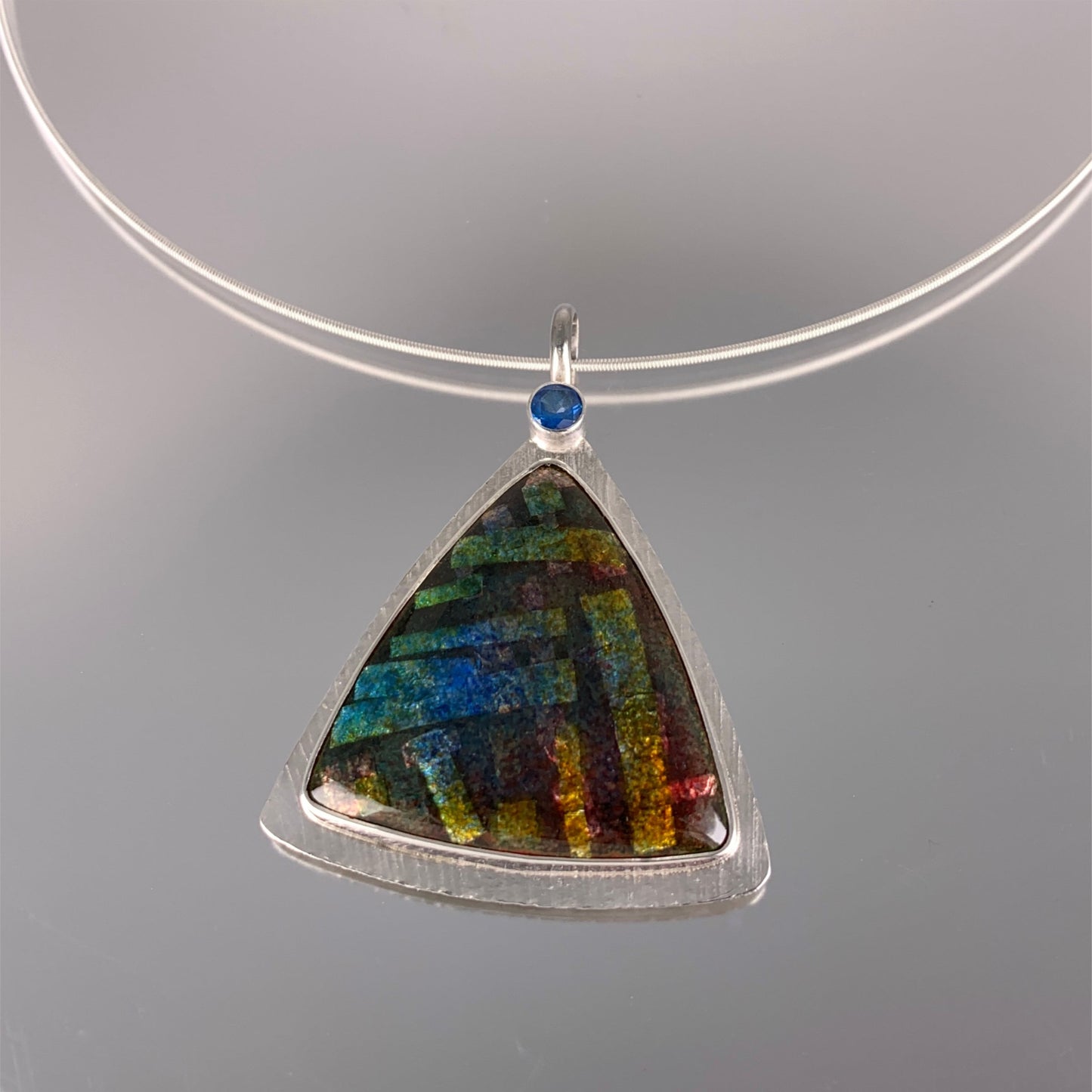 organic kiln fired enamel pendant with electric blue faceted topaz in sterling silver setting
