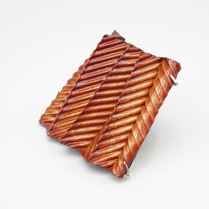 statement brooch of folded and corrugated enameled copper set in sterling silver